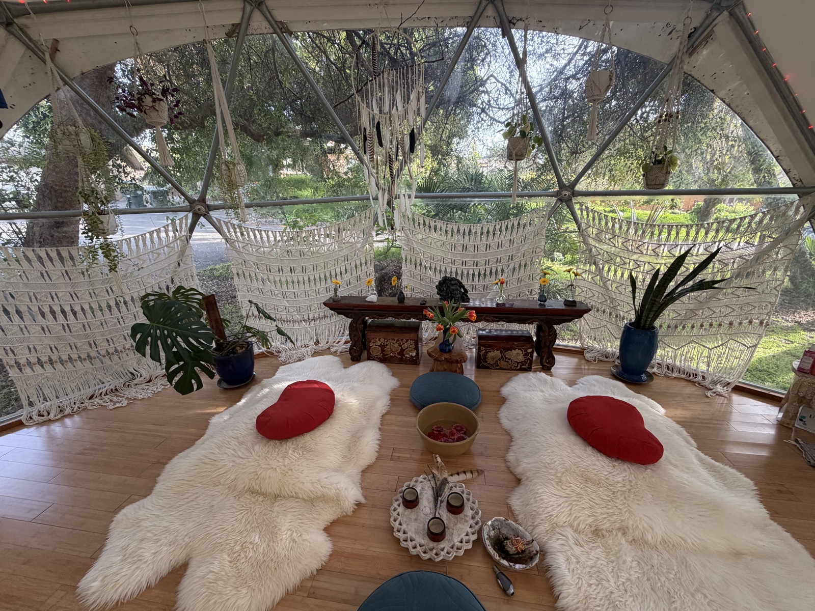 The interior of the Aum Dome with altar, macrame, and sheepskins