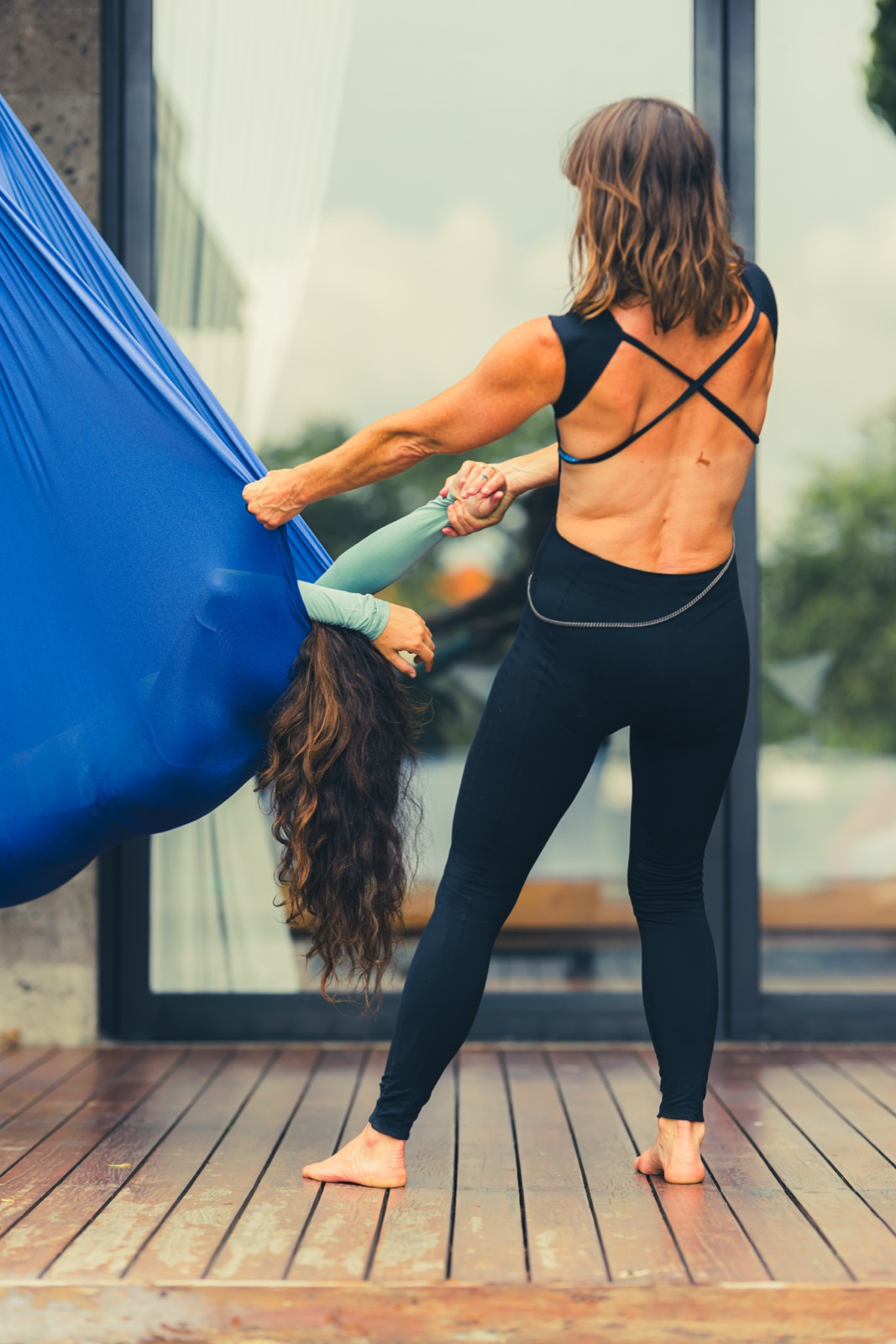 A practitioner cradling a client's head as they rest suspended in the Somatic Swing